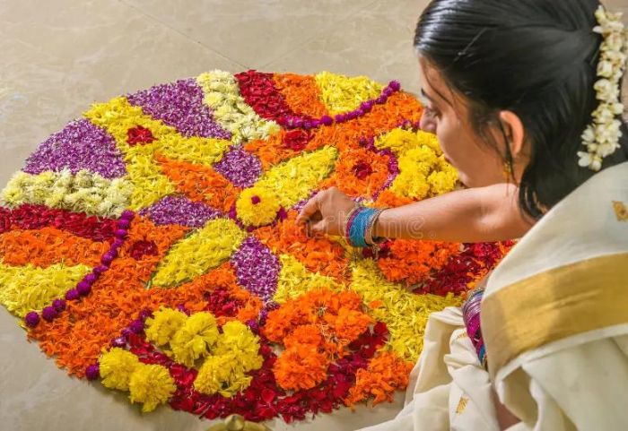 women doing onam pookalam